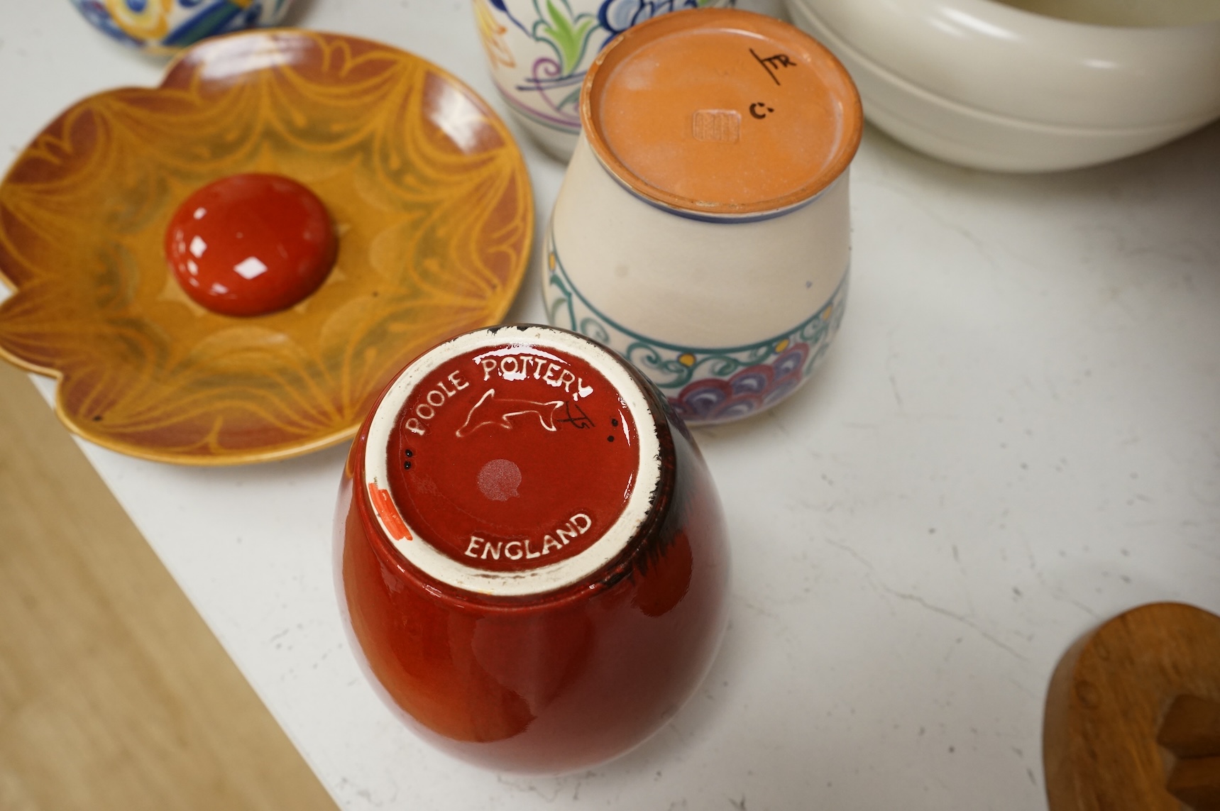 A collection of eight Poole pottery pieces to include vases, bowls and a jar and cover, largest 28cm in diameter